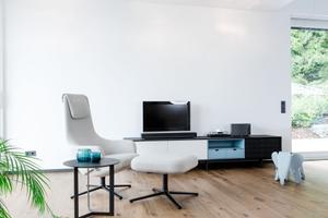 Zurücklehnen lässt es sich im Sessel Repos von Vitra vor dem Lowboard Aura von Treku.