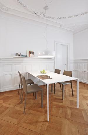 Der schlichte Esstisch Nuur harmoniert perfekt mit den komplett aus Leder bezogenen Stühlen Yessica und der Hängeleuchte Smithfield von Flos.