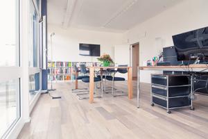 Die Arbeitsplatz und Besprechung sind in dem hellen Raum nebeneinander angeordnet und mit Systemmöbeln von USM Haller und Arbeitsstühlen von Vitra möbliert.