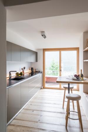 Viel Licht setzt die zeitlose und funktionale Küche b3 von Bulthaup perfekt in Szene. Barhocker CH56 von Carl Hansen.