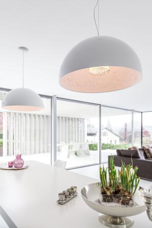 Für Überraschung am Esstisch sorgen die Hängeleuchten Skygarden von Flos, die außen schlicht in weiß glänzen und mit einem Innenleben aus Stuck überraschen.
