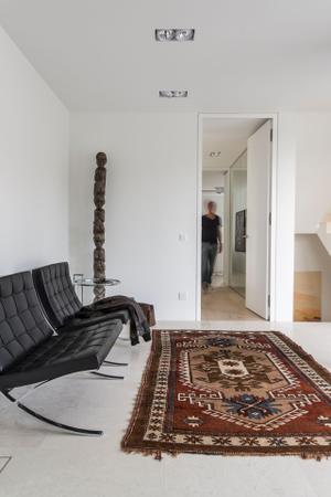 Im Eingangsbereich des modernen Hauses werden die Gäste empfangen. Sessel Barcelona von Knoll International, Beistelltisch Adjustable von Classicon, Design Eileen Gray.
