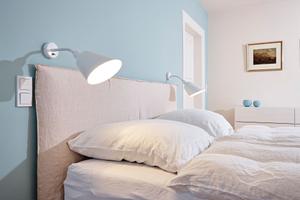 Die Wandleuchte Bellevue von Arne Jasobsen bietet perfektes Licht zum Lesen am Bett.