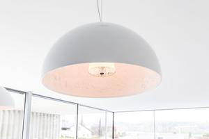 Für Überraschung am Esstisch sorgen die Hängeleuchten Skygarden von Flos, die außen schlicht in weiß glänzen und mit einem Innenleben aus Stuck überraschen.